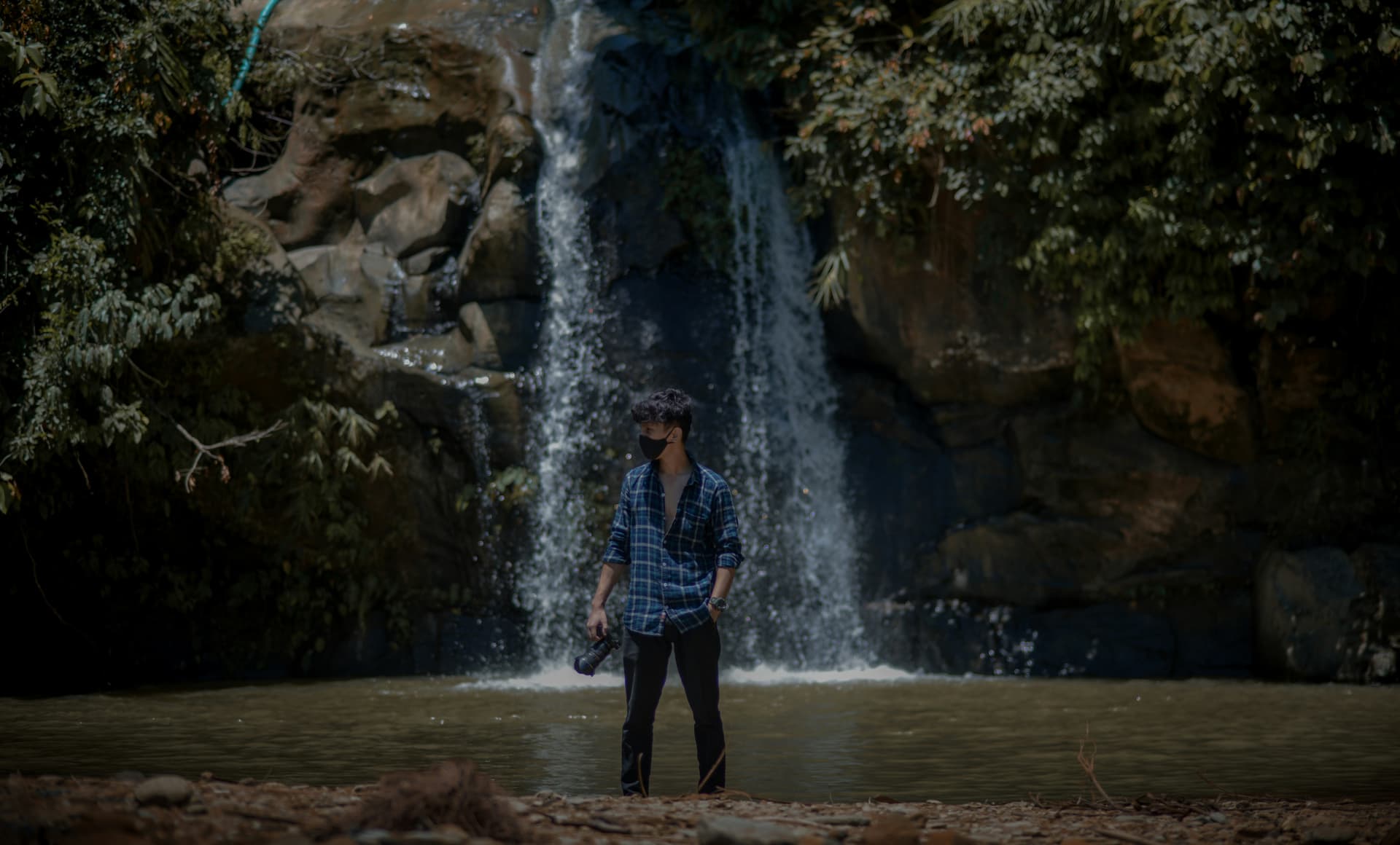 a man standing in front of a waterfall
