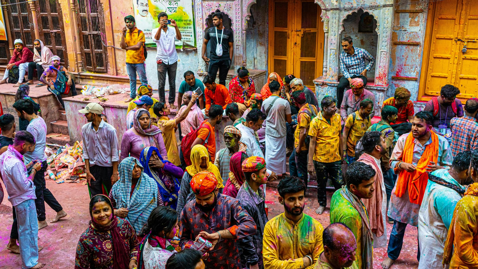 Crowd of people celebrating a festival with colored powder.
