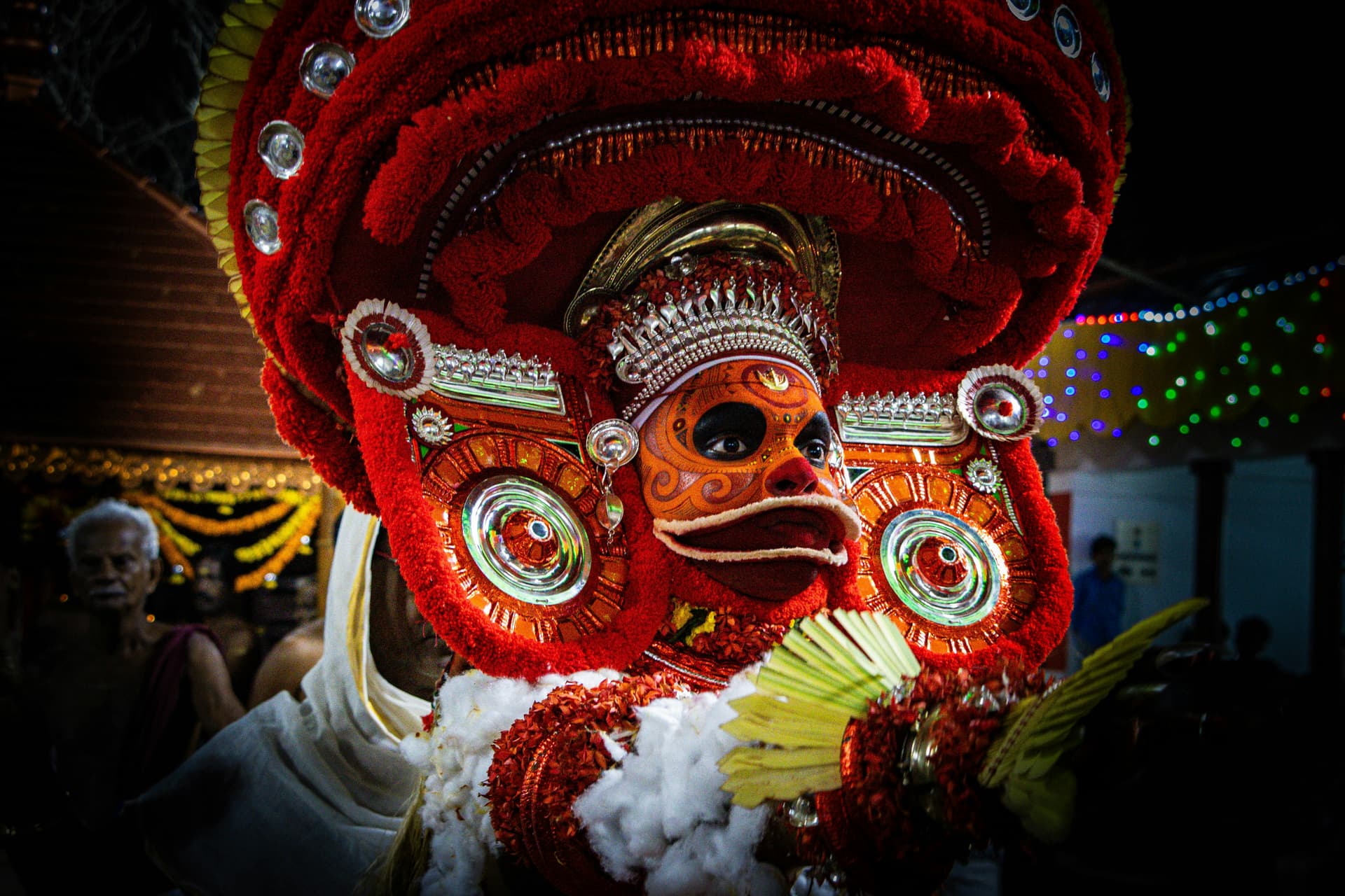 A person in elaborate red costume and mask