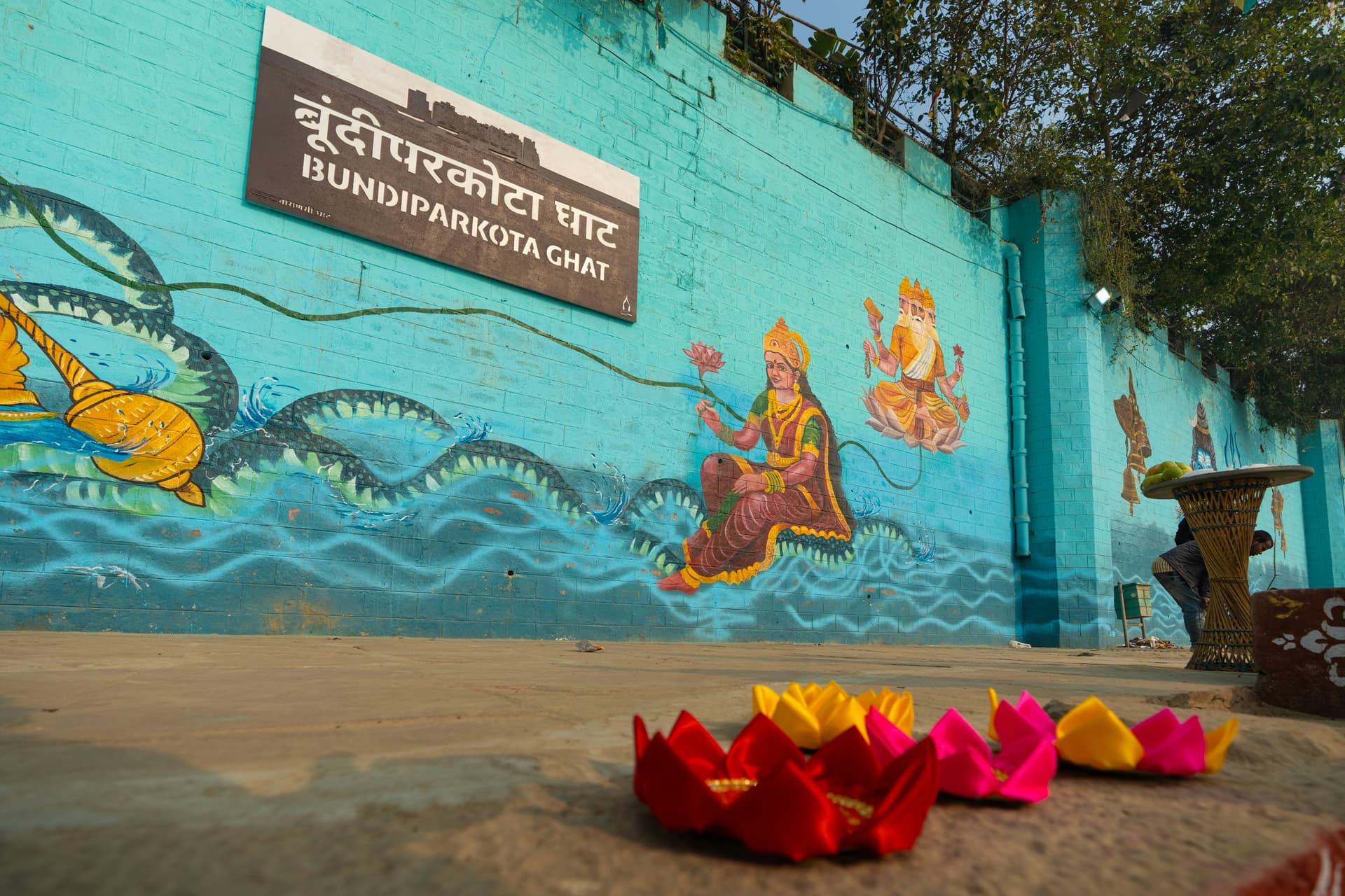 Colorful lotus flowers on ground with mural wall